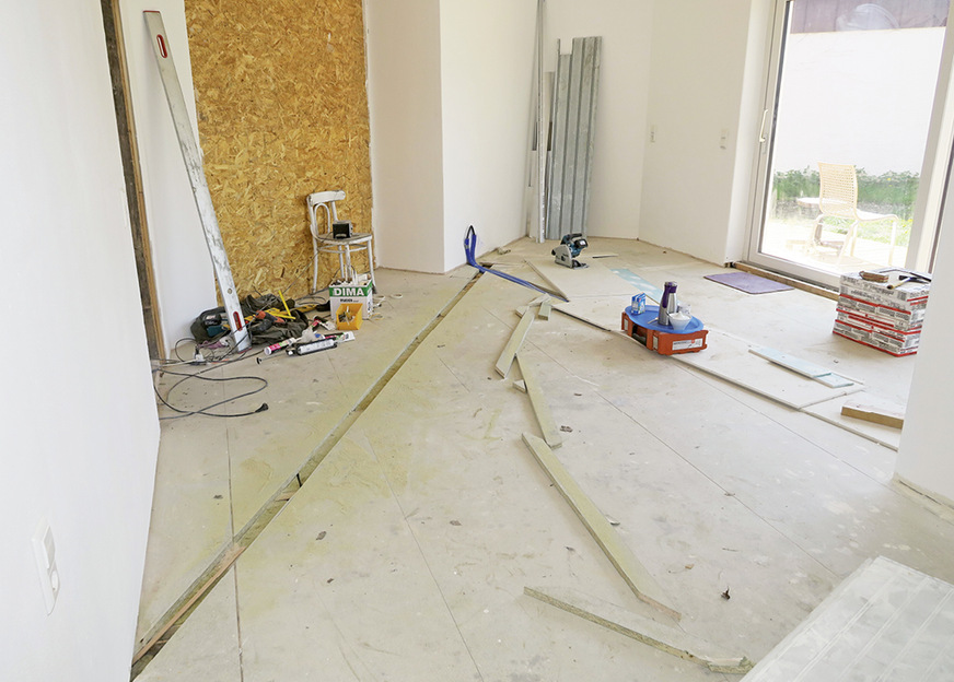 Blick in den Aufstellraum des wasserführenden Kaminofens mit den ­bereits in den Trockenestrich gefrästen Vor- und Rücklaufleitungen&nbsp;zum/vom Pufferspeicher, der sich im Technikraum befindet.