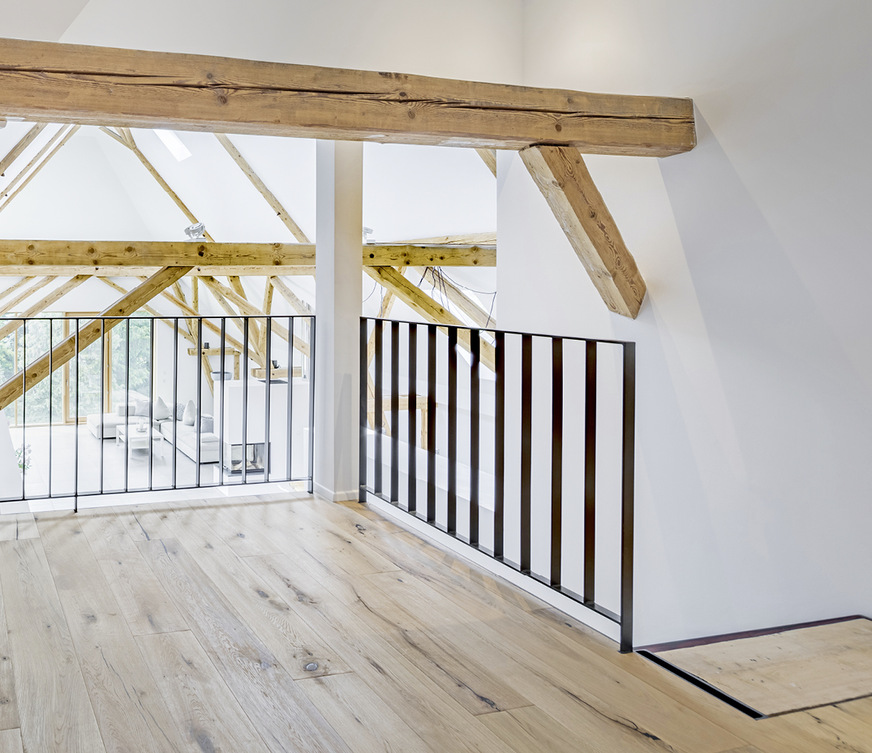 Eine offene Stahltreppe mit Galerie erschließt die Zwischenebene. Bodenbelag: Eichenparkett.