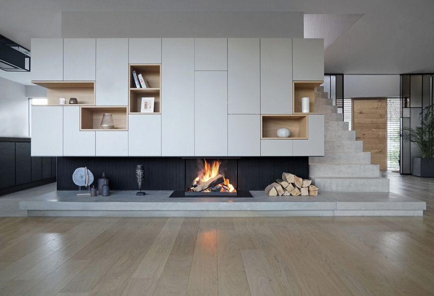 Ein Kunststück wider die Natur des Feuers: Wohnwand mit integrierter offener Feuerstelle