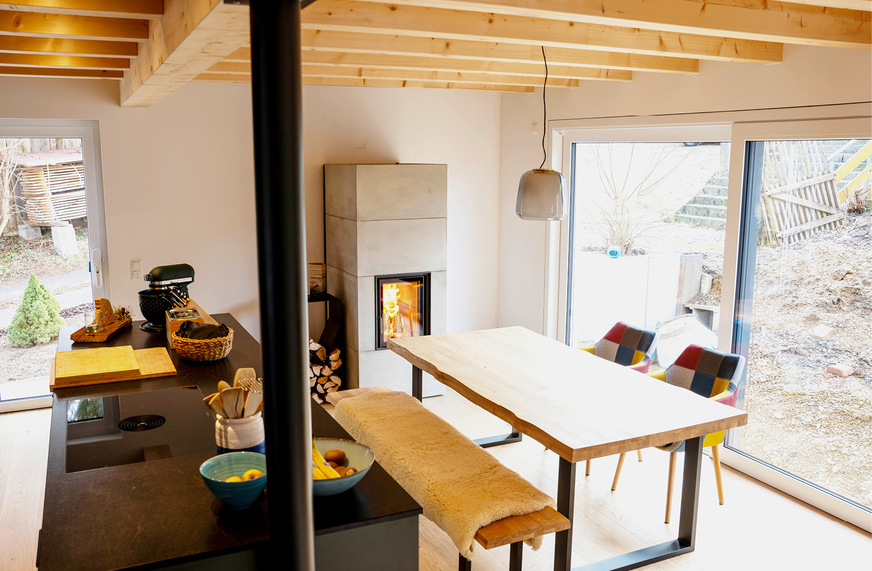 Der gemütliche offene Wohnküchen­bereich profitiert sehr von der Ofenheizung.