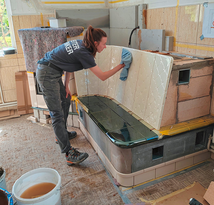 Helene verleiht der Rückenlehne des Kachelofens im rumänischen Kinderhaus den letzten Schliff.