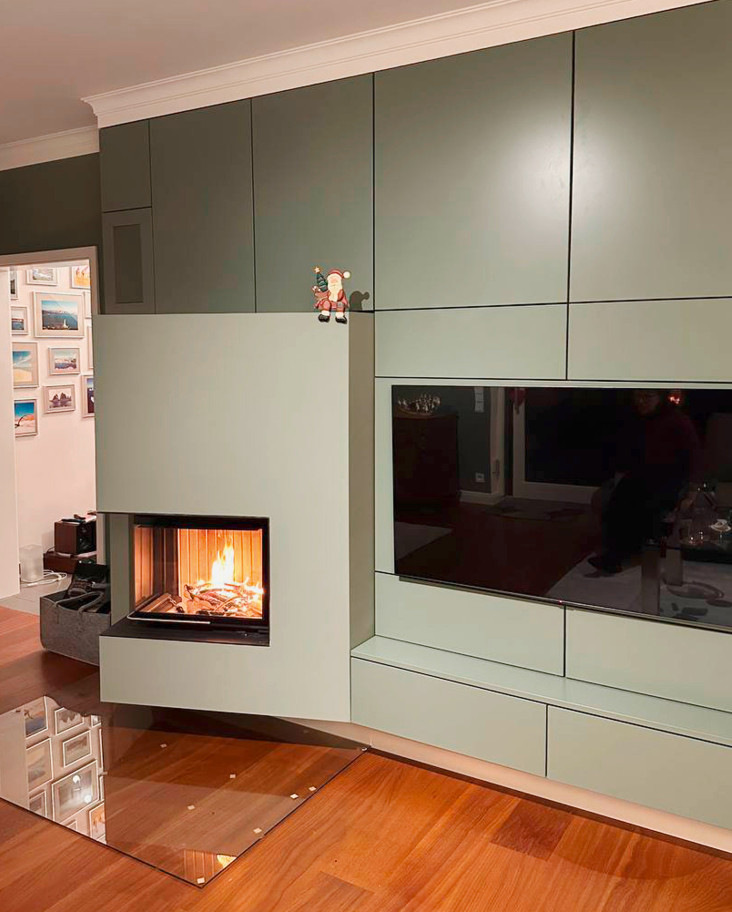Minimalistischer Einbau-Kamin wird zum Blickfang einer Möbelwand. Julian Stern