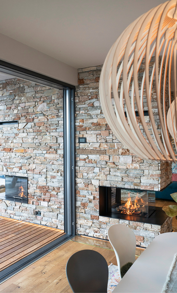 Blick vom Essplatz: Nur die Glasschiebetür trennt die attraktiven Feuerstellen mit den beiden verschiedenen Heizeinsätzen von Spartherm.