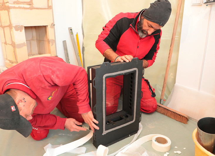 Hightech trifft traditionellen Grundofenbau: Einzig durch die patentierte Glasheiztür gelangt die Verbrennungsluft über spezielle, im Türrahmen integrierte Luftkanäle in den Brennraum. Die den Ofenkern berührenden Eckbereiche werden rundherum mit hochtemperaturbeständigem Glasfaser-Dichtband umhüllt.