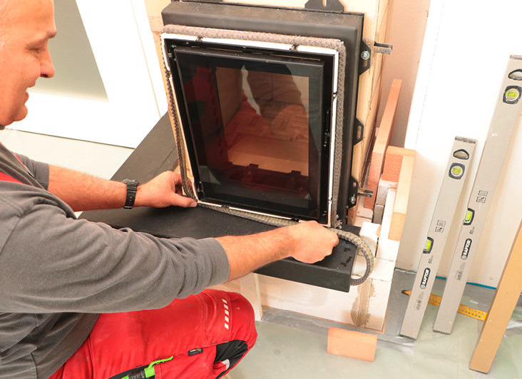 Im nächsten Schritt bringt der Ofensetzer dann dort, wo später die Schamottesteine der Ofenhaut an den Türrahmen stoßen, eine Glasfaser-Dichtschnur an, um die Wärmeausdehnung aufzufangen.