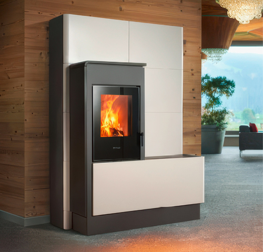 Der Kombiofen „E228 H“ ist eine zweiteilige Designlösung. Der Hauptkörper mit dem Heizeinsatz ist in den hinteren Teil integriert, der ­vollständig aus Majolika besteht, auf Gleitführungen montiert ist und den Pelletbehälter verdeckt.