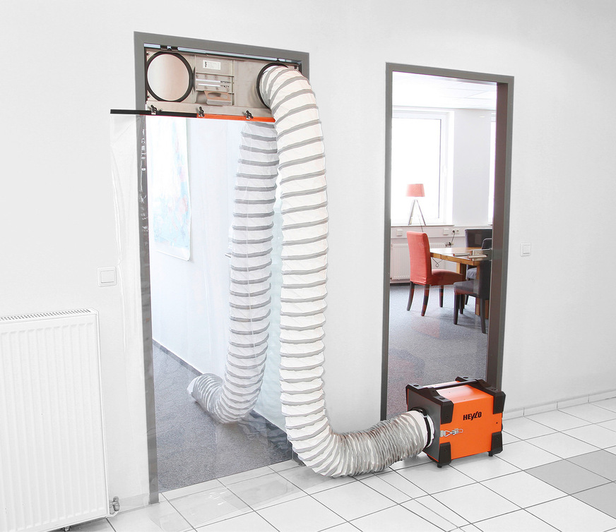 Heylo bietet eine BG-förderfähige Staubschutz-Systemlösung aus Luftreiniger DCS-PF 1000, Staubschutztür DCD 3.0, Stutzen, Vorfilter + Feinstaubfilter (F9/Klasse M) und 5 m Luftschlauch an.
