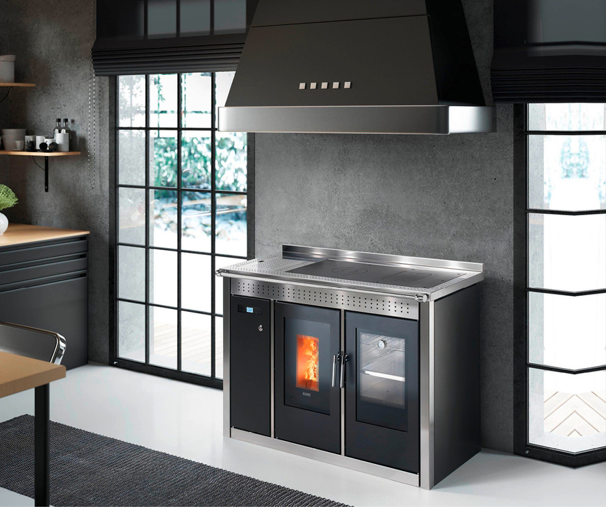 Klover – Smart 120 InoxDer Smart 120 Inox ist ein wasserführender Pellet-Herdofen mit Backrohr. Mit einer Wasserwärmeleistung von gut 17,5 kW heizt er das gesamte Haus. Der Smart 120 wird in zwei Versionen hergestellt: eine moderne Version mit Verkleidung Inox satiniert und eine rustikale Version mit Kacheln. Optional sind auch zwei thermische Klappen in Inox für die Gussplatte und das Backrohr erhältlich, die eine höhere Wärmeabgabe an das Wasser ergeben, wenn sie während des Ofenbetriebs geschlossen sind, gleichzeitig aber die Wärmeabgabe an die Raumluft verringern. Der spezielle Wärmetauscher bedient sich des „Wasserbad“-Prinzips und ermöglicht eine Anlage mit geschlossenem Expansionsgefäß, während das Produkt mit „Sicuro TOP“ ein eingebautes offenes Gefäß aufweist und somit nicht unter Druck steht. Sollte das Wasser zum Kochen kommen, besteht mit diesem System nicht mehr die Gefahr eines Druckanstiegs. Der Druck im Inneren des Kesselkörpers bleibt gleich null. Ein Überlaufrohr gewährleistet beim Sieden die Sicherheit, indem überschüssiges Wasser aus dem oberen Behälter abgelassen wird, während das Nachfüllen des Wassers je nach Modell über eine automatische oder manuelle Vorrichtung erfolgt.