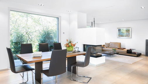 Sehr schön belichtet ist der Essplatz über bodentiefe Verglasungen und dem Blick auf den Kamin.