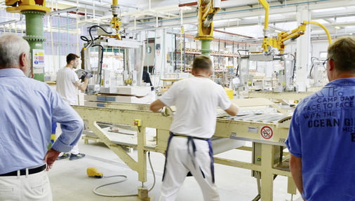 Die schweren Formen, in die die keramische Masse gegossen wird, werden mit Roboterarmen von einer Station zur nächsten getragen.