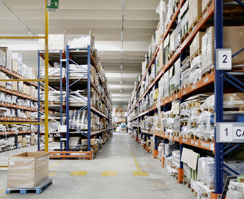 Links und rechts Regale mit Rohmaterialien für die industrielle Ofenfertigung.