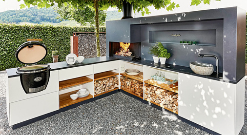  Die OutdoorKüche von Kipf besticht durch klare Formen­sprache ohne Kompromisse in der Ausstattung und Verarbeitung. Der gesamte Korpus ist von Hand verschraubt, und dennoch sieht man keine einzige Schraube. Das stimmige Gesamtbild aus pulverbeschichteten Präzisionsplatten aus Seealuminium wird durch eine Abdeckplatte aus geflammtem Nero Assoluto abgerundet. Die Einlegeböden aus Eichenvollholz bilden den harmonischen Kontrast zum ­soliden Aluminium und dem tiefschwarzen Nero Assoluto.