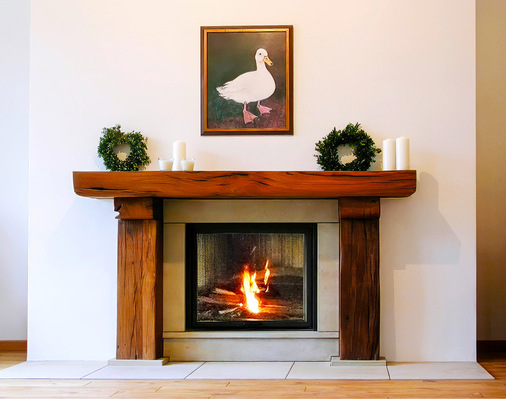 Niermann Ofenbau schuf diese rustikale Kamineinfassung aus antiken Holzbohlen.