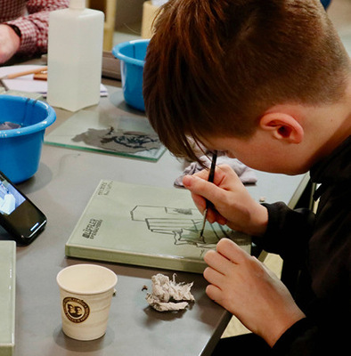Ein Nachwuchstalent bei der Handbemalung von ­Ofenkeramik.