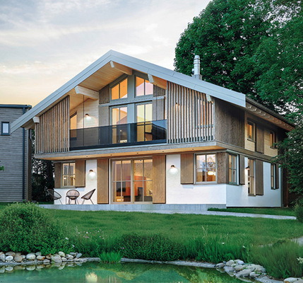 Ein Haus im zeitlos schönen, alpinen Chalet Stil und dennoch erkennbar traditionellen Zügen –   „durch und durch“ nachhaltig aus vorwiegend regionalem Holz, von der Fassade bis zur Dämmung in Holzfaser. Und im Mittelpunkt der außergewöhnliche Ofen.