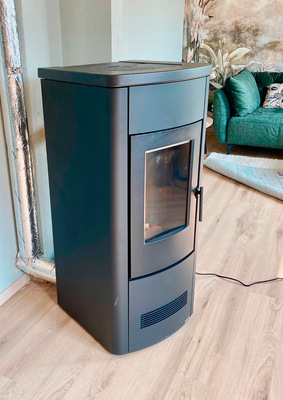 Hier ist der Ofen bereits installiert, die Warmluft­leitungen verschwinden noch hinter Blenden.