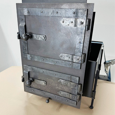 Feuer-Asche-Geschränk Modell Schmiede-eisen. Das Modell besticht mit seiner rauen, dunklen Optik. Die herb-wilde Oberfläche wird teilweise gehämmert. Die Zierbänder mit Nietenoptik runden den Schmiede-Look ab.