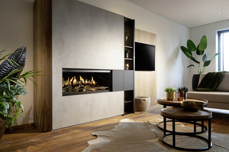 Kamin  „ E-one ” , der ausschließlich mit Strom aus der Steckdose funktioniert. Keramikholzscheite und LED-Glutbett bieten in Kombination mit HD-Holographie-Flammen ein authentisches Kaminerlebnis, das überall installiert werden kann und dabei keinerlei Nebenwirkung auf Umwelt und Gesundheit hat.