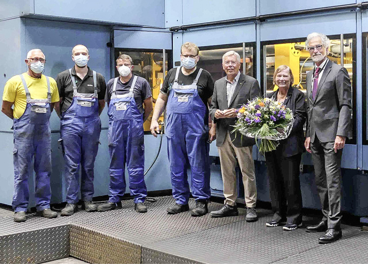 Jubilarin Hilke Wolff mit Ehemann Fritz Wolff (links neben ihr) im Kreise von Betriebsratsvorsitzenden Siegbert Knoop (Mitte), langjährigen Betriebsmitarbeitern und Geschäftsführer Folkmar Ukena (rechts). Im Hintergrund die weltweit modernste Hochdruckformanlage DISMATIC D5.