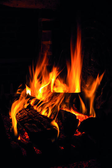 Lagerfeuerromantik in den eigenen vier Wänden: Die offene Flamme hat im Laufe der Jahrhunderte nichts von ihrer Faszination verloren, entsprechend beliebt sind Kaminöfen. Wer möglichst bequem und effizient heizen möchte, sollte jedoch eher auf einen Pelletkaminofen setzen. - © txn-Foto: annamoskvina/123rf/VZBV
