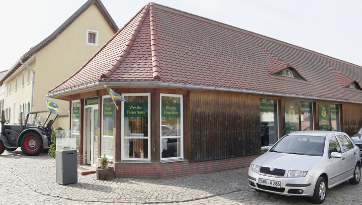 Im Vordergrund das pittoreske Westbo Feuerhaus mit der Ofenausstellung, dahinter im Gelben ­Gebäude, dem ehemaligen Gasthaus Grüne Tanne, das Schulungs- und Eventzentrum. - © Foto: Martin Henze
