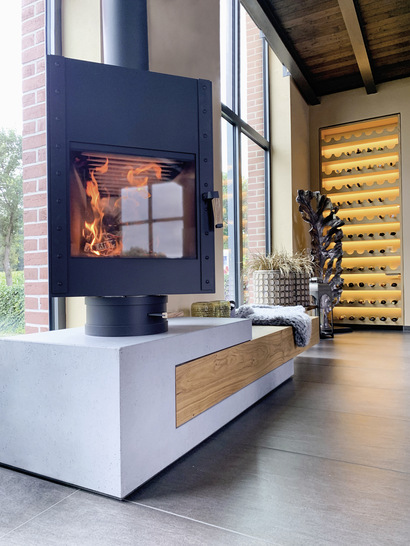 Handgefertigte Beton-Kaminbank mit Holzbalken und Leenders-Kaminofen.