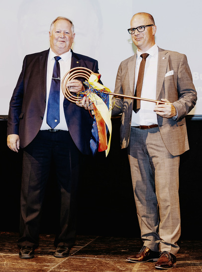 Der ehemalige Vorsitzende Joachim Butz gratuliert dem frisch gewählten Vorsitzenden Stefan Menrath zur Wahl und überreicht symbolisch den Schlüssel zur Geschäftsstelle. - © Foto: FV SHK BW
