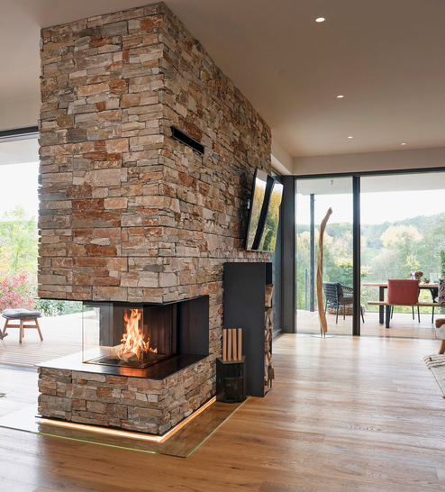 Hell, weiträumig, großzügig – und mittendrin eine beeindruckende Kamin-Anlage, die den offenen Wohn-, Ess- und Küchen­bereich in den kühlen Jahreszeiten mit angenehmer Holzwärme versorgt.