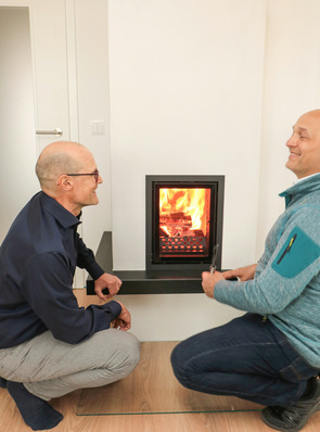 Pure Freude beim Hauseigentümer Stefan Böckler (links) und Ofenbauer Roman Dreesbach über die gelungene Arbeit und den faszinierenden Feuerzauber, der jetzt das Wohnen in der kalten Jahreszeit bereichert.